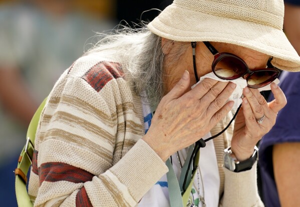 M. Sally Nakai Kobayashi wipes her eyes during a flag ceremony with a 48-star World War II-era flag she and other survivors of incarceration signed outside the visitor center at the Minidoka National Historic Site, Saturday, July 8, 2023, in Jerome, Idaho. Kobayashi, who was born at Minidoka and grew up in Chicago, now lives in Sapporo, Japan, where she gives presentations on Japanese American incarceration. (AP Photo/Lindsey Wasson)