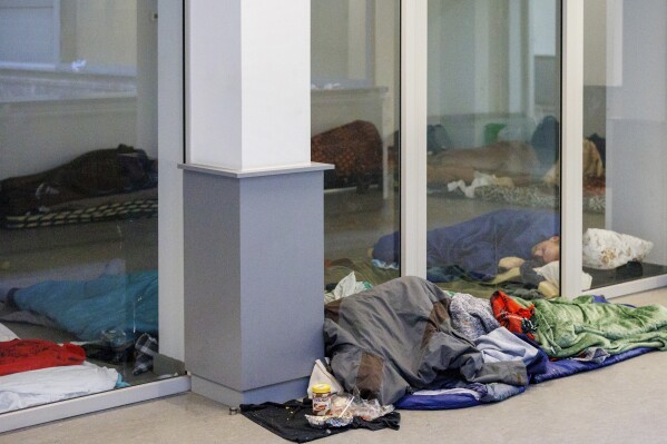FILE - Migrants sleep on the floor of a squatted building in Brussels, on Jan. 31, 2023. The Belgian government said Wednesday Aug. 30, 2023 it is imposing a ban on providing shelter for single men seeking asylum, arguing its insufficient reception capacity should be freed for families, women and children first. Aid organizations condemned the move as reneging on international commitments. (AP Photo/Olivier Matthys, File)