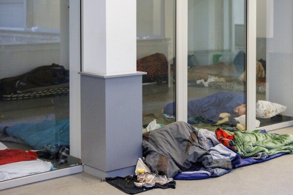 FILE - Migrants sleep on the floor of a squatted building in Brussels, on Jan. 31, 2023. The Belgian government said Wednesday Aug. 30, 2023 it is imposing a ban on providing shelter for single men seeking asylum, arguing its insufficient reception capacity should be freed for families, women and children first. Aid organizations condemned the move as reneging on international commitments. (AP Photo/Olivier Matthys, File)