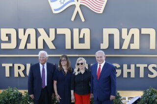 FILE - In this June 16, 2019, file photo, Israeli Prime Minister Benjamin Netanyahu, right, his wife Sara, United States Ambassador to Israel David Friedman, left, and his wife Tammy pose during the inauguration of a new settlement named after President Donald Trump in the Golan Heights, An Israeli cabinet minister on Sunday, June 14, 2020, said the government approved plans to build a new settlement in the Israeli-occupied Golan Heights named after Trump. Settlements Minister Tzipi Hotovely wrote on Facebook that her ministry will start preparations for Ramat Trump — Hebrew for “Trump Heights” — to house 300 families. (AP Photo/Ariel Schalit, File)