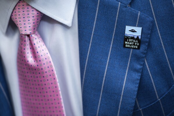 An audience member wears a UFO pin during a House Oversight and Accountability subcommittee hearing on UFOs, Wednesday, July 26, 2023, on Capitol Hill in Washington. (AP Photo/Nathan Howard)