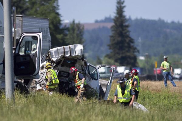 Oregon State Police troopers and firefighters work near the site of a wrecked tractor-trailer Thursday, May 18, 2023,calong Interstate 5 in Albany, Ore. Mulitple people were killed and others hurt in a crash involving multiple vehicles Thursday on Interstate 5 near Albany, Oregon, police said. (Alex Powers/Albany Democrat-Herald via AP)