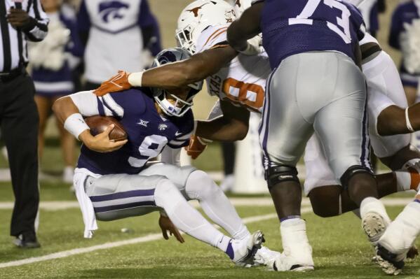 Kansas State quarterback Adrian Martinez (9) is sacked by Texas defensive end Barryn Sorrell (88) during the first half of an NCAA college football game Saturday, Nov. 5, 2022, in Manhattan, Kan. (AP Photo/Reed Hoffmann)