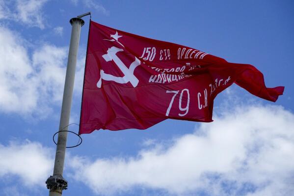 FILE - A red flag, a replica of the Victory banner flutters in the wind over the central square of Melitopol, Zaporizhzhia region, in a territory under Russian military control, southeastern Ukraine, May 1, 2022. (AP Photo, File)