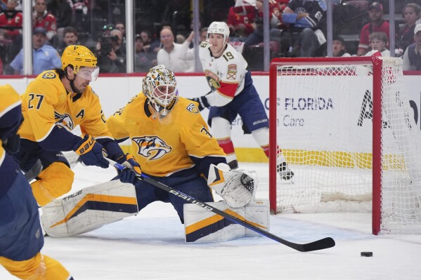 Nashville Predators goaltender Kevin Lankinen (32) watches the puck go wide as defenseman Ryan McDonagh (27) closes in on the puck during the first period of the team's NHL hockey game against the Florida Panthers, Thursday, March 21, 2024, in Sunrise, Fla. (AP Photo/Jim Rassol)