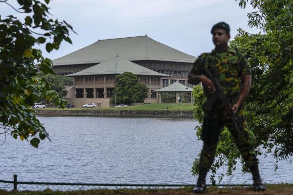 An army soldier soldier stands guard outside the parliament building in Colombo, Sri Lanka, Saturday, July 16, 2022. Sri Lankan lawmakers met Saturday to begin choosing a new leader to serve the rest of the term abandoned by the president who fled abroad and resigned after mass protests over the country's economic collapse. (AP Photo/Rafiq Maqbool)