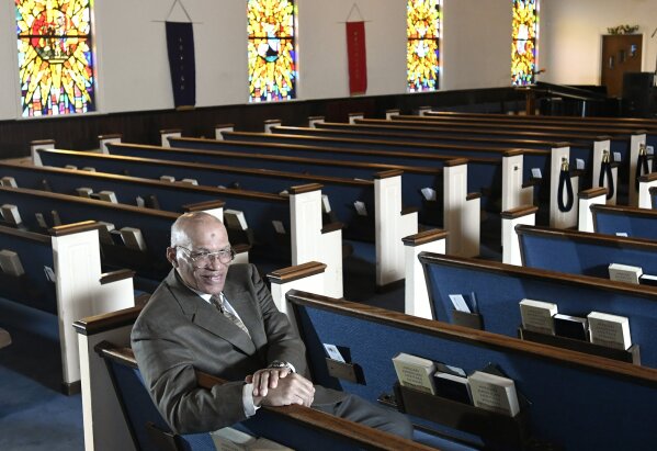 FILE - In this Thursday, March 19, 2020 file photo, the Rev. Alvin J. Gwynn Sr., of Friendship Baptist Church in Baltimore, sits for a portrait in his church. Gwynn said that police tried to halt services at his church on Sunday, March 29, 2020, even though he had limited in-person attendance to 10 people. (AP Photo/Steve Ruark)