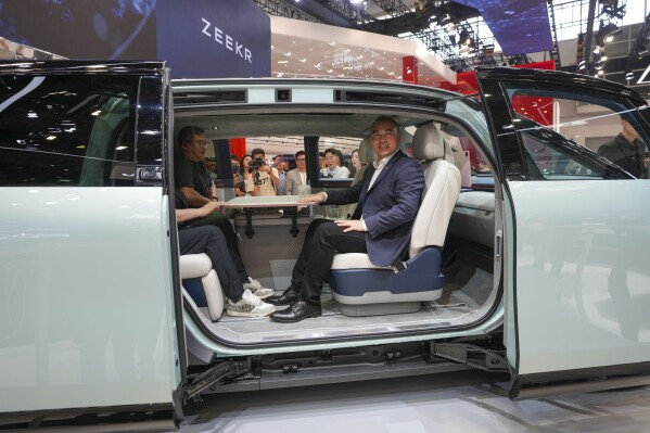 Visitors sit inside a Zeekr Mix car during the China Auto Show in Beijing, China, Friday, April 26, 2024. China's vision of the future of the automobile electrified and digitally connected is on display at the ongoing Beijing auto show. (AP Photo/Tatan Syuflana)