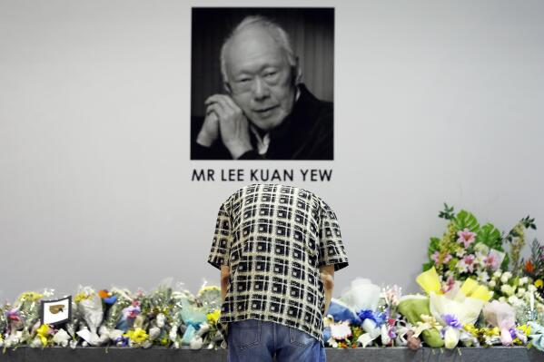 A man bows to pay his respects to the late Lee Kuan Yew at a community club where members of the public can gather to express their condolences, Monday, March 23, 2015, in Singapore. Singaporeans wept and world leaders paid tribute Monday as the Southeast Asian city-state mourned the death of its founding father Lee Kuan Yew. The government announced that Lee, 91, "passed away peacefully" several hours before dawn at Singapore General Hospital. (AP Photo/Wong Maye-E)