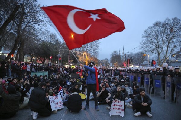 University students sit next to anti riot police officers during a protest after Istanbul's Mayor Ekrem Imamoglu was arrested and sent to prison, in Istanbul, Turkey, Monday, March 24, 2025. (AP Photo/Huseyin Aldemir, File)
