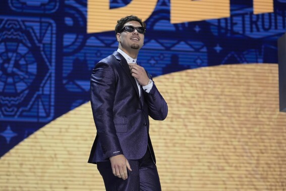 UCLA defensive lineman Laiatu Latu walks on stage during the first round of the NFL football draft, Thursday, April 25, 2024, in Detroit. (AP Photo/Jeff Roberson)