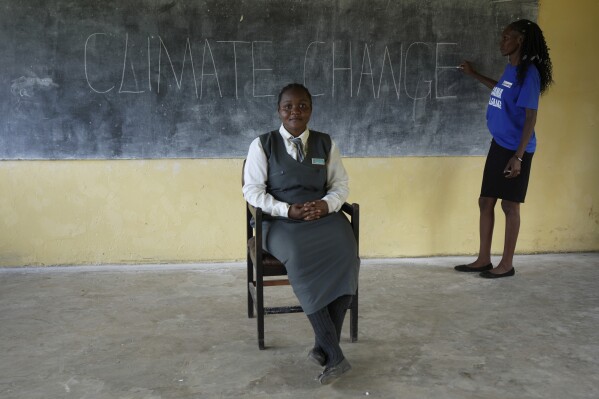 Elizabeth Motale, right, a climate agriculture expert, prepares for a climate change lesson at Chileshe Chepela Special School, as Bridget Chanda takes up her position in front of the class so she can be able to serve as a sign language interpreter before a lesson in Kasama, Zambia, Wednesday, March 6, 2024. Chanda is intent on helping educate Zambia’s deaf community about climate change. As the southern African nation has suffered from more frequent extreme weather, including its current severe drought, it’s prompted the Zambian government to include more climate change education in its school curriculum. (AP Photo/Tsvangirayi Mukwazhi)