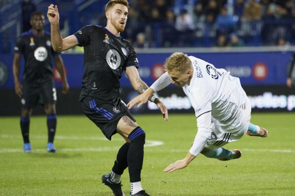 New England Revolution forward Adam Buksa falls after colliding with CF Montréal defender Joel Waterman during the second half of an MLS soccer game in Montreal on Wednesday, Sept. 29, 2021. (Paul Chiasson/The Canadian Press via AP)