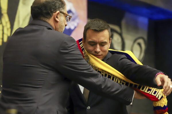National Assembly President Henry Kronfle places the presidential sash on incoming President Daniel Noboa after he was sworn-in during his inauguration ceremony at the National Assembly, in Quito, Ecuador, Thursday, Nov. 23, 2023. Noboa, an inexperienced politician and heir to a fortune built on the banana trade, said his government's main objective will be to "reduce violence and make progress a habit." (AP Photo/Juan Diego Montenegro)