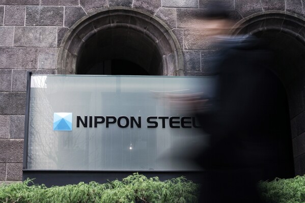 A person walks past a Nippon Steel Corporation sign at the company headquarters on Jan. 7, 2025, in Tokyo. (AP Photo/Eugene Hoshiko, File)
