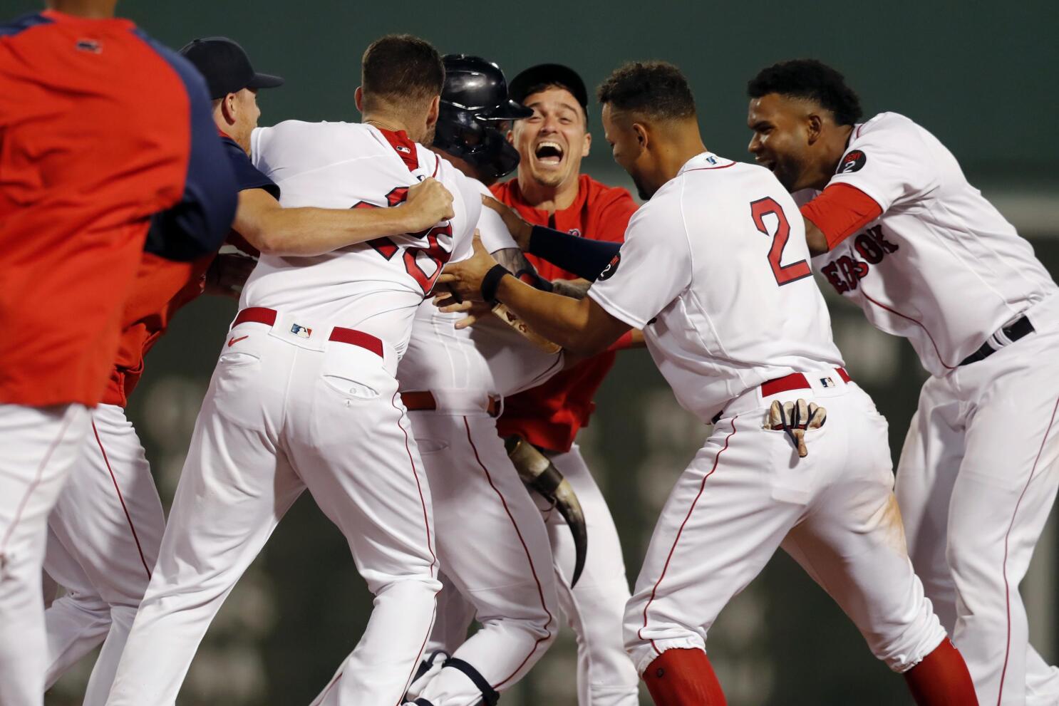 Boston Red Sox players waving to teammates in dugout from second