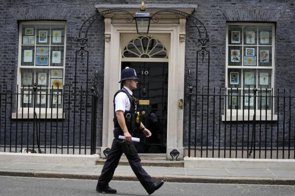 A police officer walks past 10 Downing Street in London, Monday, May 23, 2022. The general public waits for the release of Sue Gray's report into COVID lockdown breaches across Whitehall, the so called "Partygate". (AP Photo/Frank Augstein)