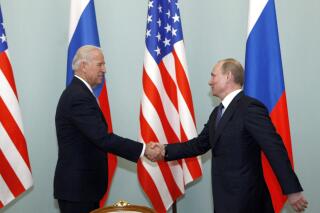 FILE - In this March 10, 2011 file photo, then U.S. Vice President Joe Biden, left, shakes hands with Russian Prime Minister Vladimir Putin in Moscow.    (AP Photo/Alexander Zemlianichenko)