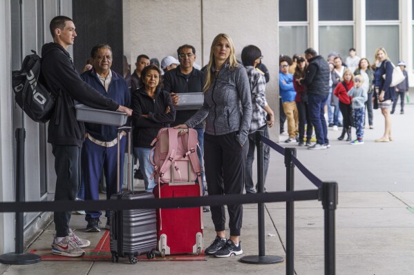 Marni Larsen and her son, Damon Rasmussen of Holladay, Utah, wait their turn in line hoping to snag her son's passport outside the Los Angeles Passport Agency at the Federal Building in Los Angeles on Wednesday, June 14, 2023. Larsen applied for her son's passport two months earlier and spent weeks checking for updates online or through a frustrating call system. (AP Photo/Damian Dovarganes)