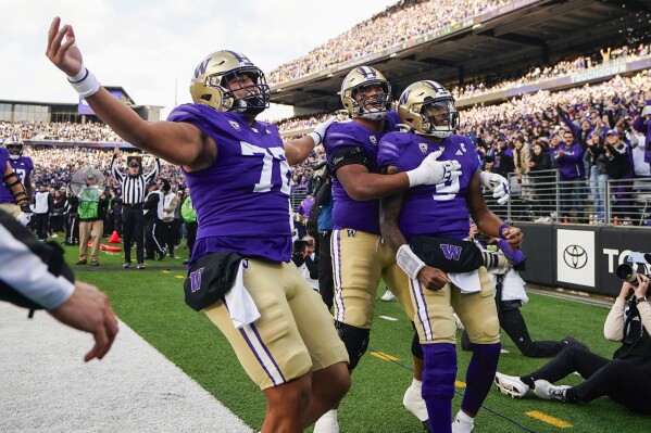 Washington quarterback Michael Penix Jr., right, celebrates his touchdown against Utah with teammates Parker Brailsford (72) and Nate Kalepo, center, during the first half of an NCAA college football game Saturday, Nov. 11, 2023, in Seattle. (AP Photo/Lindsey Wasson)