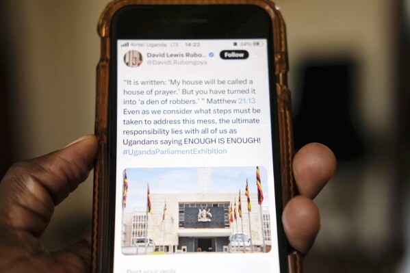 A view of a local scrolling on the X app formerly known as Twitter on a smartphone, in Kampala, Uganda Monday, March 4, 2024. An online protest campaign exposing corruption has rattled government officials and others in Uganda, where street protests are practically outlawed. The campaign, which relies on leaks of official documents, has been presented on the social media platform X as an “exhibition” — in a sequence of postings — about controversial issues, from failing hospitals to potholes in the streets of Kampala, the Ugandan capital. (AP Photo/Ajar Nalwadda)