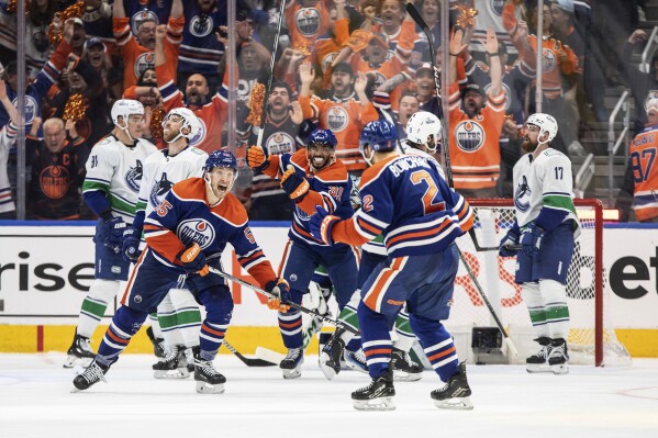 Edmonton Oilers' Evan Bouchard (2), Dylan Holloway (55) and Evander Kane (91) celebrate a goal against the Vancouver Canucks during the third period of Game 4 of an NHL hockey second-round playoff series, Tuesday, May 14, 2024, in Edmonton, Alberta. (Jason Franson/The Canadian Press via Ǻ)