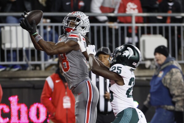 Ohio State receiver Marvin Harrison, left, catches a touchdown over Michigan State defensive back Chance Rucker during the first half of an NCAA college football game Saturday, Nov. 11, 2023, in Columbus, Ohio. (AP Photo/Jay LaPrete)