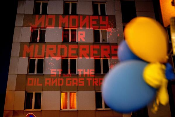 FILE - The words "No Money for Murderers, Stop the Oil and Gas Trade" are projected by activists onto the Russian consulate in Frankfurt, Germany, April 4, 2022. Europe is discussing a boycott of Russian oil over the Kremlin's invasion of Ukraine. As Russia's biggest customer for oil, the 27-country European Union could deal a blow to President Vladimir Putin's state finances. But Europe would face higher prices and such a move would send an oil shock through a global economy that's still rebounding from the COVID-19 pandemic. (AP Photo/Michael Probst, file)
