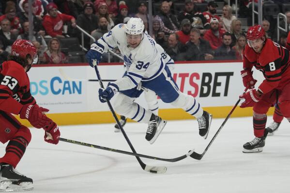 Toronto Maple Leafs center Auston Matthews (34) shoots as Detroit Red Wings defenseman Moritz Seider (53) and Detroit Red Wings defenseman Ben Chiarot (8) defend in the first period of an NHL hockey game Monday, Nov. 28, 2022, in Detroit. (AP Photo/Paul Sancya)