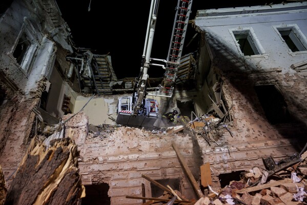 Rescue workers clear the rubble of a university building destroyed by a Russian missile strike on Sumy, Ukraine, Sunday, April 13, 2025. (AP Photo/Evgeniy Maloletka)