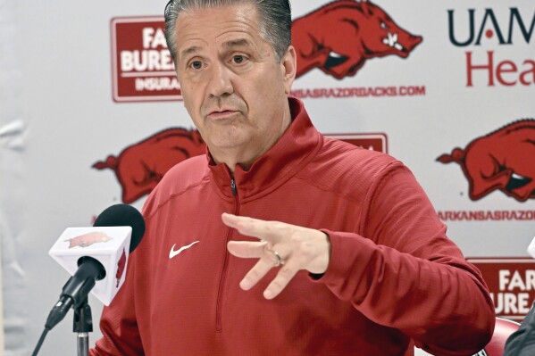 FILE - John Calipari answers questions from reporters during a news conference after being introduced as the new Arkansas head basketball coach April 10, 2024, in Fayetteville, Ark. Calipari will face his former team at Kentucky next season. The Southeastern Conference released home and away opponents for its 16 basketball teams including new members Oklahoma and Texas, Monday, May 13, 2024. (AP Photo/Michael Woods, File)