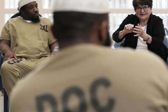 Sister Helen Prejean, right, talks as Richard Obot, left, detainee in Division Of Correction 11, listens to her during a book club at Department Of Corrections Division 11 in Chicago, Monday, April 22, 2024. DePaul students and detainees are currently reading Dead Man Walking and the author, anti death penalty advocate, Sister Helen Prejean attended to lead a discussion. (AP Photo/Nam Y. Huh)