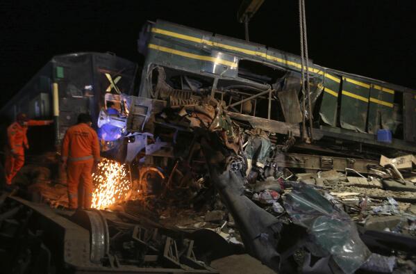 Railway workers try to clear the track at the site of a train collision in the Ghotki district, southern Pakistan, late Monday, June 7, 2021. An express train barreled into another that had derailed in Pakistan before dawn Monday, killing dozens of passengers, authorities said. More than 100 were injured, and rescuers and villagers worked throughout the day to search crumpled cars for survivors and the dead. (AP Photo/Fareed Khan)