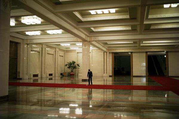 A man cleans a carpet inside the Great Hall of the People prior to the arrival of French President Emmanuel Macron, in Beijing, China, Thursday, April 6, 2023. (AP Photo/Thibault Camus)