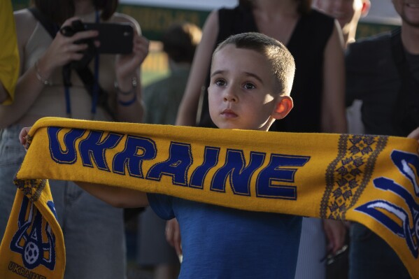 Mikhail, 5 holds a scarf with the inscription "Ukraine" during a public screening of the Euro 2024 match between Ukraine and Belgium in Kyiv, Ukraine, on Wednesday, June 26, 2024. (AP Photo/Alex Babenko)