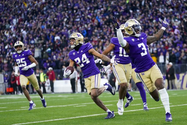 Washington safety Makell Esteen (24) runs with safety Mishael Powell (3) after making an interception against Washington State during the second half of an NCAA college football game Saturday, Nov. 25, 2023, in Seattle. (AP Photo/Lindsey Wasson)