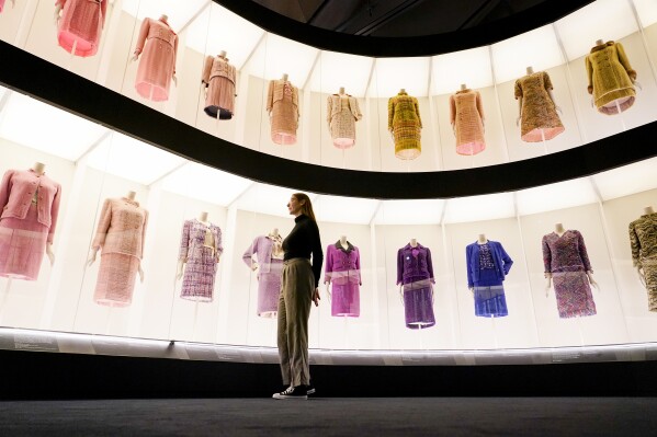 A curator poses next to creations which are displayed as part of the "Gabrielle Chanel. Fashion Manifesto" exhibition at the Victoria and Albert museum, in London, Tuesday, Sept. 12, 2023.(AP Photo/Alberto Pezzali)