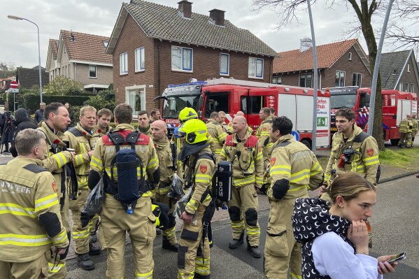 Firefighters gather in Eden, Netherlands, Saturday, March 30, 2024. Heavily armed police have cordoned off part of a Dutch town and say that multiple people are being held hostage in a building there. It is unclear how many people are being held. Police said in a message on X, formerly Twitter, that “at the moment there is no indication of a terrorist motive.” (AP Photo/Aleksandar Furtula)