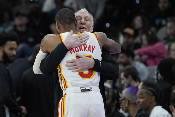 San Antonio Spurs head coach Gregg Popovich, right, hugs Atlanta Hawks guard Dejounte Murray (5) before an NBA basketball game in San Antonio, Sunday, March 19, 2023. Murray is a former Spurs player. (AP Photo/Eric Gay)