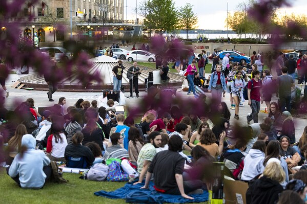 Ein Musiker tritt auf, während pro-palästinensische Demonstranten gegen ihr Lager in der Library Mall auf dem Campus der University of Wisconsin in Madison protestieren, Mittwoch, 1. Mai 2024.  (Samantha Madar/Wisconsin State Journal über AP)