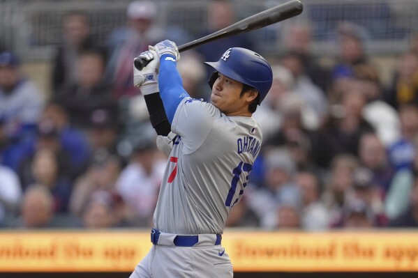 Los Angeles Dodgers designated hitter Shohei Ohtani hits a double during the first inning of a baseball game against the Minnesota Twins, Monday, April 8, 2024, in Minneapolis. (AP Photo/Abbie Parr)