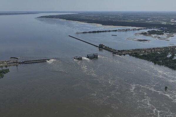 FILE - Water flows over the collapsed Kakhovka Dam in Nova Kakhovka, in Russian-occupied Ukraine, June 7, 2023. An AP investigation has found that Russian occupation authorities vastly and deliberately undercounted the dead in one of the most devastating chapters of the 22-month war in Ukraine - the flooding that followed the catastrophic explosion that destroyed the Kakhovka Dam in the southern Kherson region. (AP Photo, File)