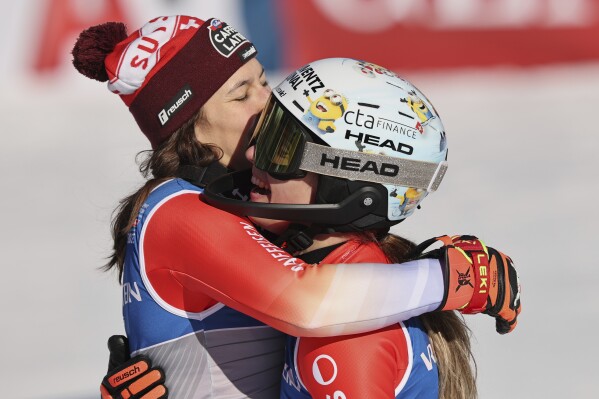 Switzerland's Wendy Holdener, left, hugs Switzerland's Camille Rast after winning the silver (Holdener) and gold medal a women's slalom, at the Alpine Ski World Championships, in Saalbach-Hinterglemm, Austria, Saturday, Feb. 15, 2025. (AP Photo/Marco Trovati)