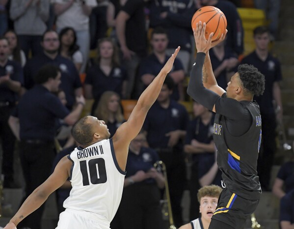 El guardia del estado de San José, Myron Amey Jr., dispara el balón mientras el guardia del estado de Utah, Darius Brown II (10), defiende durante la segunda mitad de un partido de baloncesto universitario de la NCAA el martes 30 de enero de 2024 en Logan, Utah.  (Eli Lucero/Herald Journal vía AP)