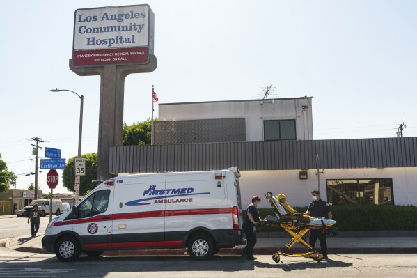 A patient is transported by ambulance outside the Los Angeles Community Hospital in East Los Angeles on Friday, Aug. 4, 2023. Hospitals, including the Community Hospital, and clinics in several states on Friday began the time-consuming process of recovering from a cyberattack that disrupted their computer systems, forcing some emergency rooms to shut down and ambulances to be diverted. (AP Photo/Damian Dovarganes)