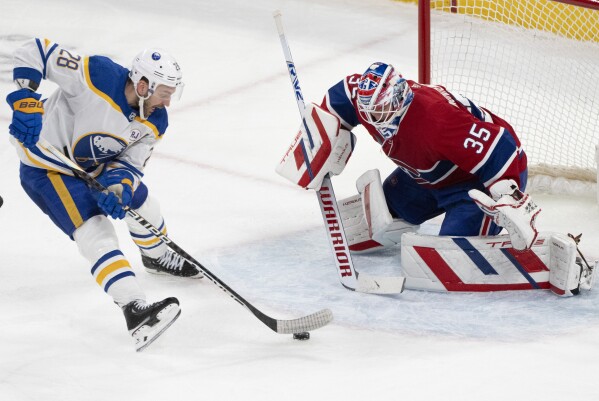 Buffalo Sabres' Zemgus Girgensons (28) drives to the net against Montreal Canadiens goaltender Sam Montembeault (35) during the third period of an NHL hockey game Wednesday, Feb. 21, 2024 in Montreal. (Christinne Muschi/The Canadian Press via AP)