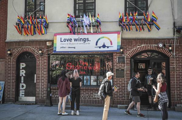 FILE - In this Monday, June 3, 2019, file photo, Pride flags and colors display on the Stonewall Inn bar, marking the site of 1969 riots that followed a police raid of the bar's gay patrons, in New York. The Stonewall Inn’s owners say they won’t serve certain beers at the famous LGBT bar during Pride weekend to protest manufacturer Anheuser-Busch’s political contributions to some politicians who have supported anti-LGBT legislation. (AP Photo/Bebeto Matthews, File)