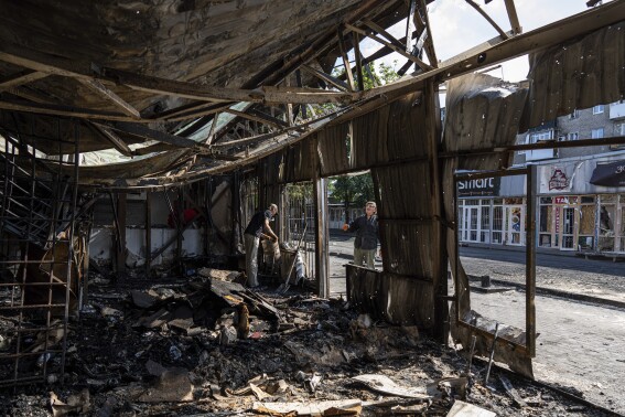 People clear the rubble of a destroyed market after yesterday's rocket attack in the city center of Kostiantynivka, Ukraine, Thursday, Sept. 7, 2023. At least 17 people were killed and 32 wounded in Wednesday’s attack on the market in Kostiantynivka, in Ukraine’s Donestsk region — another grim reminder of the war’s civilian toll. (AP Photo/Evgeniy Maloletka)