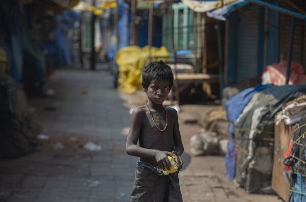 A homeless boy collects rotten fruits from a deserted fruit market during lockdown in Gauhati, India, Wednesday, March 25, 2020. The world's largest democracy went under the world's biggest lockdown Wednesday, with India's 1.3 billion people ordered to stay home in a bid to stop the coronavirus pandemic from spreading and overwhelming its fragile health care system as it has done elsewhere. For most people, the new coronavirus causes mild or moderate symptoms, such as fever and cough that clear up in two to three weeks. For some, especially older adults and people with existing health problems, it can cause more severe illness, including pneumonia and death. (AP Photo/Anupam Nath)
