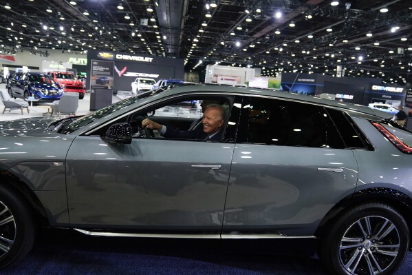 FILE - President Joe Biden drives a Cadillac Lyriq through the show room during a tour at the Detroit Auto Show Sept. 14, 2022, in Detroit. Former President Donald Trump and other Republicans portray Biden's policy to promote electric vehicles as unfair for consumers and government overreach. Biden and Democrats have been less vocal and more nuanced, advocating Biden's climate reduction goals while promoting homegrown technology over competition from China. (AP Photo/Evan Vucci, File)